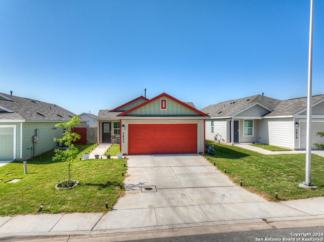 view of front of home with an attached garage, driveway, and a front lawn