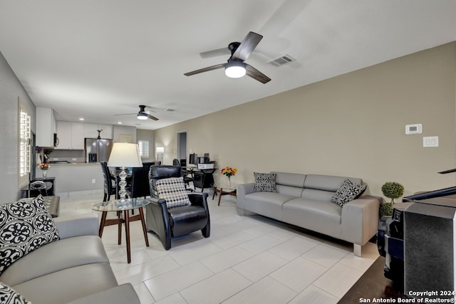 tiled living room with ceiling fan