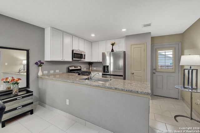 kitchen featuring stainless steel appliances, white cabinets, visible vents, and a peninsula