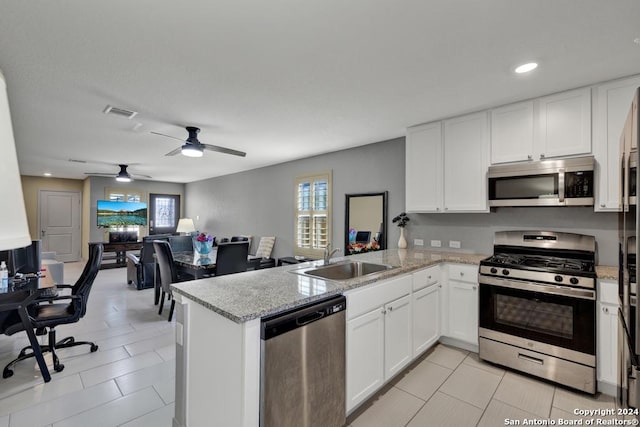 kitchen featuring a peninsula, white cabinetry, appliances with stainless steel finishes, and a sink