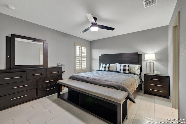 bedroom with light tile patterned floors, ceiling fan, and visible vents