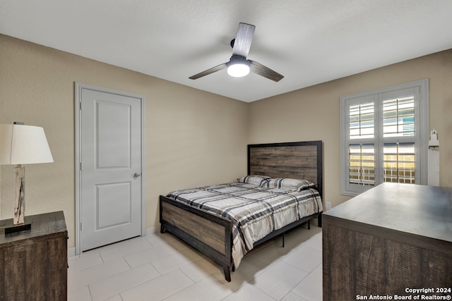 tiled bedroom featuring ceiling fan