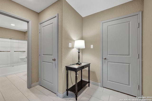 hallway with baseboards and light tile patterned floors