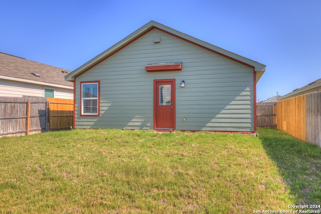 rear view of property featuring a yard