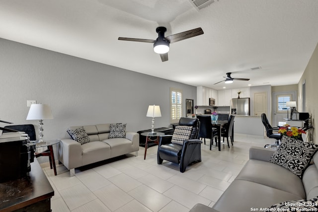 living room with ceiling fan and light tile patterned floors