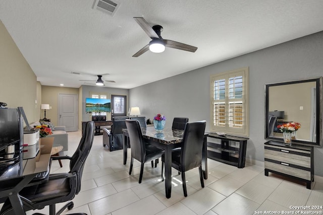 dining area with a textured ceiling, light tile patterned flooring, plenty of natural light, and visible vents