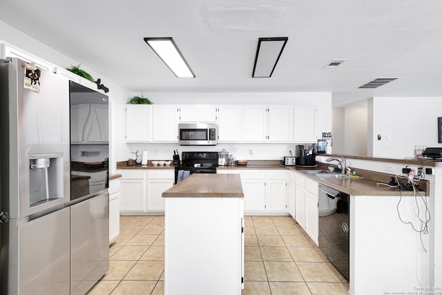 kitchen featuring light tile patterned floors, sink, black appliances, and white cabinetry