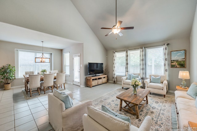 living room with high vaulted ceiling, ceiling fan with notable chandelier, and light tile patterned floors