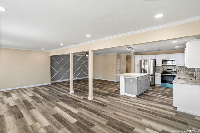 basement featuring ornamental molding, sink, wood-type flooring, and stainless steel refrigerator with ice dispenser