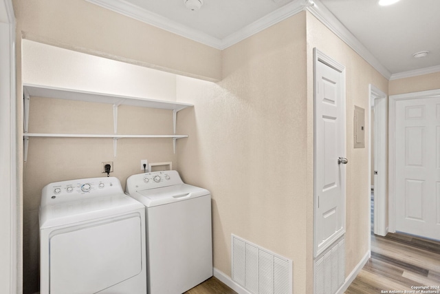 clothes washing area with light wood finished floors, laundry area, ornamental molding, and visible vents