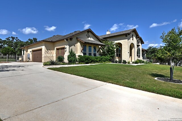 mediterranean / spanish home featuring a front lawn and a garage