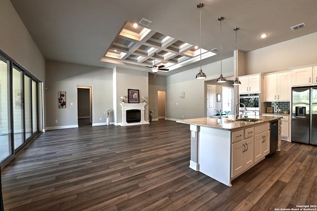 kitchen featuring appliances with stainless steel finishes, an island with sink, white cabinetry, and pendant lighting