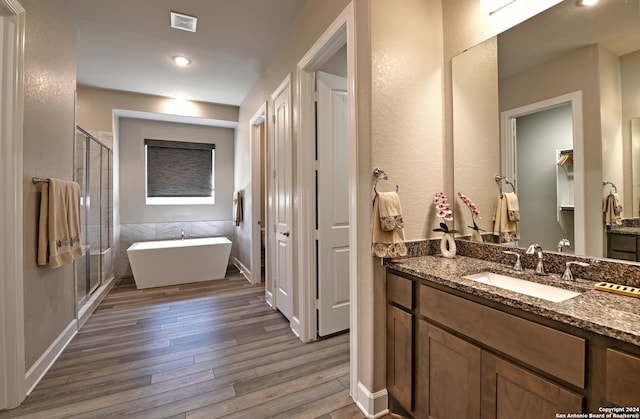 bathroom with vanity, wood-type flooring, and separate shower and tub