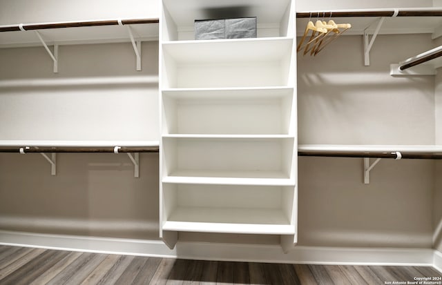 walk in closet with hardwood / wood-style floors