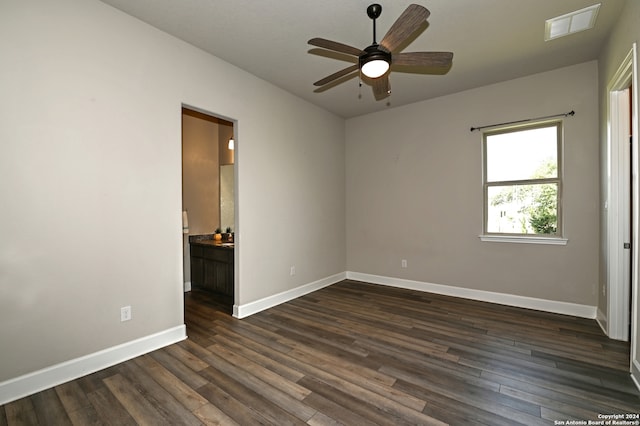 spare room featuring dark wood-type flooring and ceiling fan