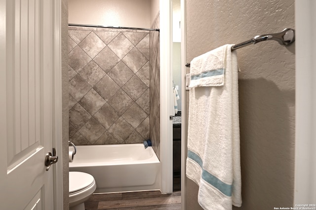 bathroom featuring tiled shower / bath combo, toilet, and hardwood / wood-style floors