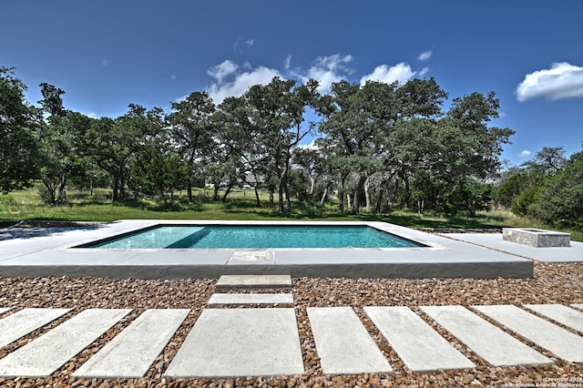 view of swimming pool with a patio area and an outdoor fire pit