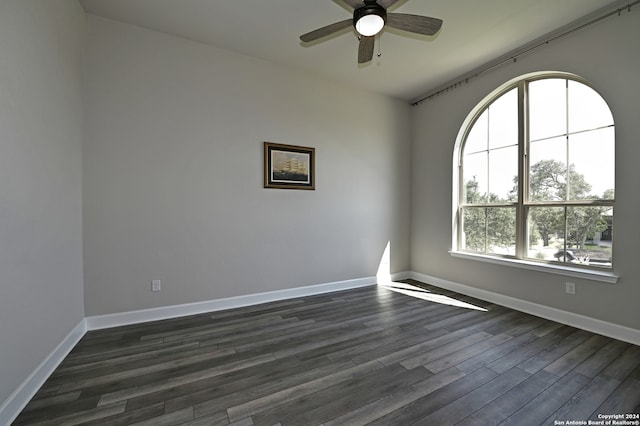 empty room with ceiling fan and dark wood-type flooring