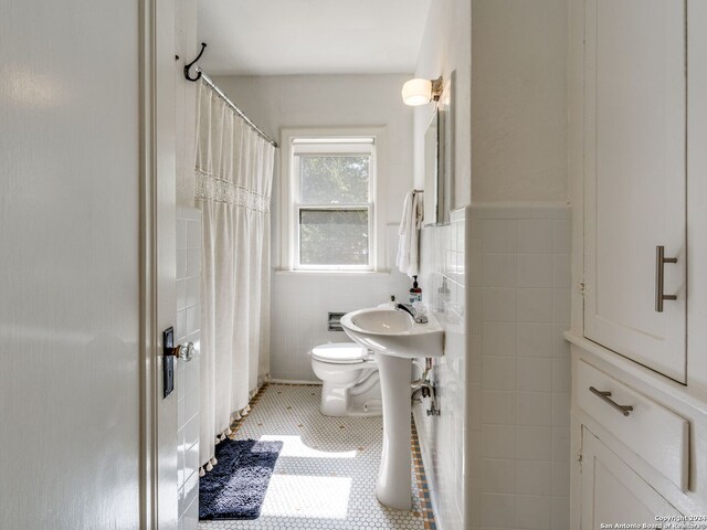 bathroom with tile walls, tile patterned flooring, and toilet