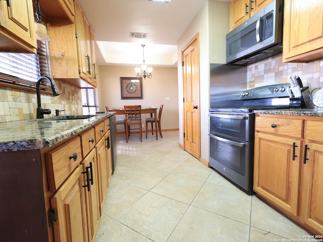 kitchen with a notable chandelier, tasteful backsplash, sink, and stainless steel appliances