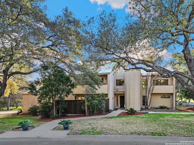 view of front of home with a balcony and a front yard