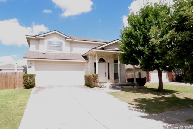 view of front of property featuring concrete driveway, stone siding, an attached garage, fence, and a front lawn