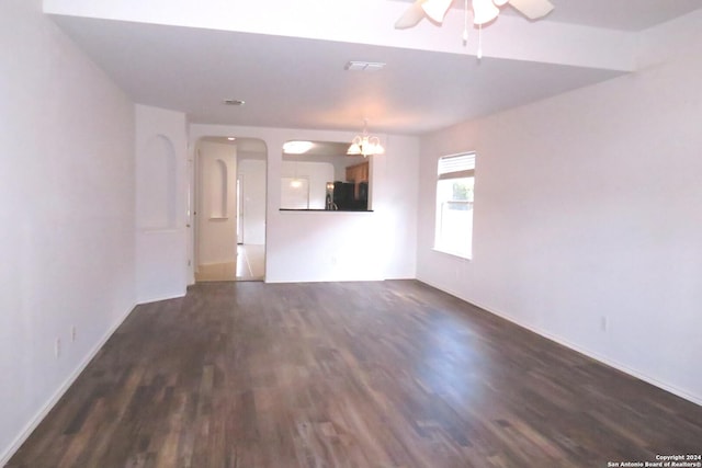 unfurnished living room with visible vents, a ceiling fan, and dark wood-style flooring