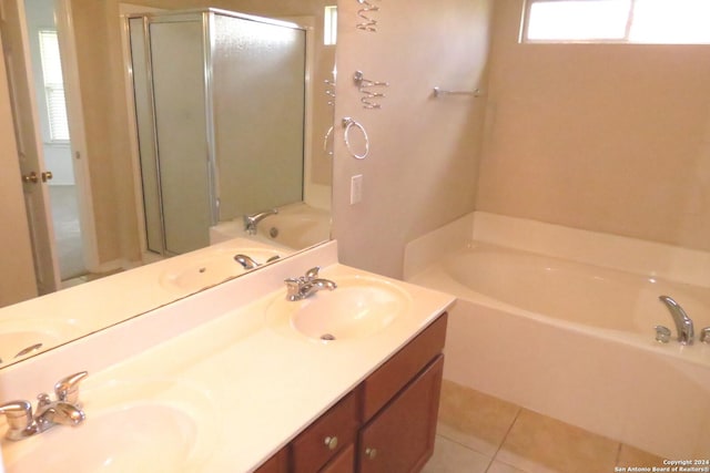 full bath with a bath, tile patterned flooring, and a sink