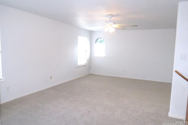 spare room featuring light carpet and ceiling fan