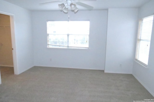 unfurnished room featuring light colored carpet and ceiling fan