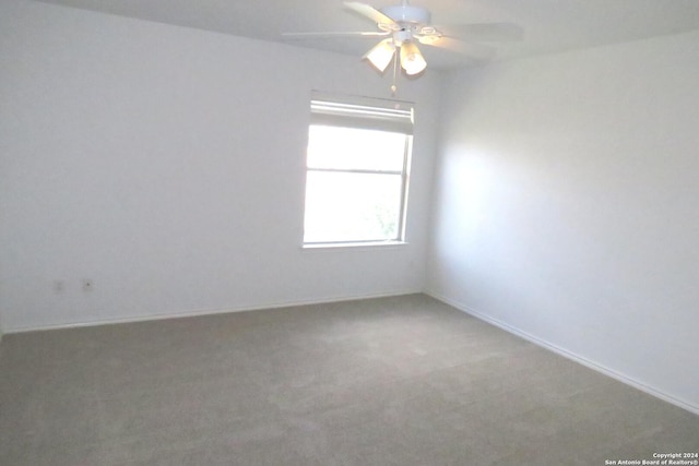 empty room featuring carpet, baseboards, and a ceiling fan