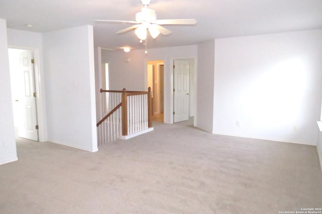 empty room with ceiling fan and light colored carpet