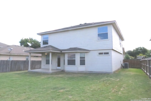 back of property with a yard, central AC unit, a patio area, and a fenced backyard