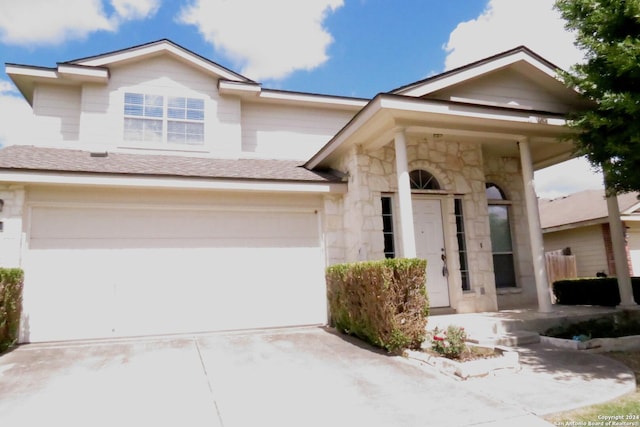 view of front of property with an attached garage, driveway, roof with shingles, and stone siding