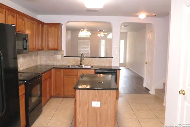 kitchen with a sink, a center island, decorative backsplash, black appliances, and dark countertops