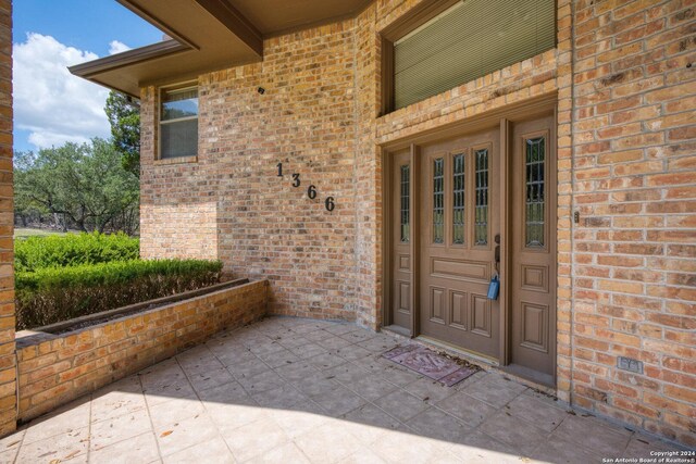 view of exterior entry featuring brick siding