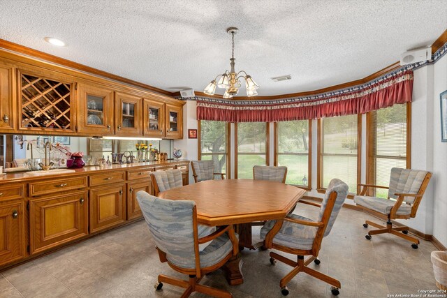 dining space with sink, a textured ceiling, light tile patterned floors, and an inviting chandelier