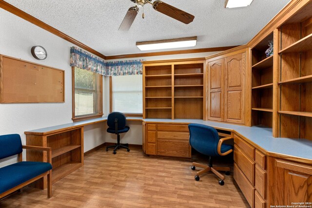 office area with a textured ceiling, built in study area, light wood-style flooring, and crown molding