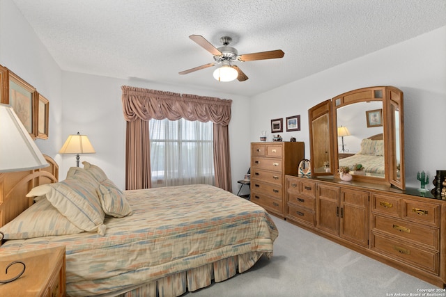 carpeted bedroom featuring a textured ceiling and ceiling fan