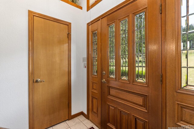 entrance foyer with light tile patterned floors and baseboards