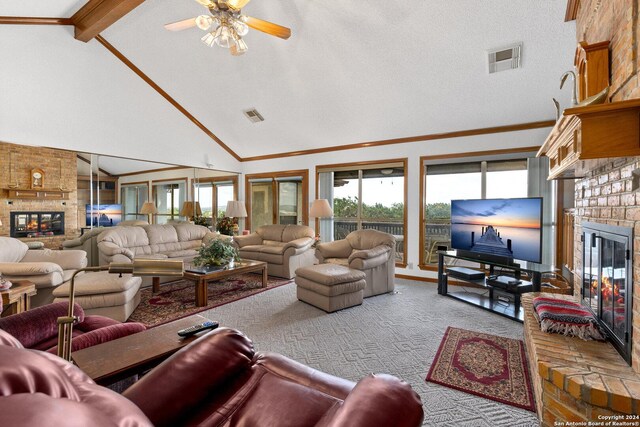 carpeted living room with ceiling fan, high vaulted ceiling, a fireplace, and brick wall