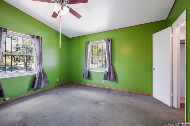 carpeted spare room featuring lofted ceiling and ceiling fan