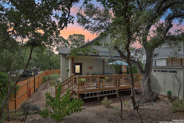 back house at dusk featuring a deck