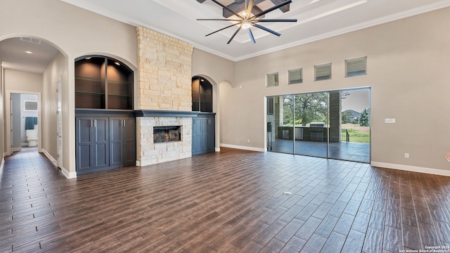 unfurnished living room with ceiling fan, a fireplace, dark hardwood / wood-style floors, and ornamental molding