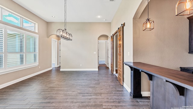 unfurnished dining area featuring a barn door and hardwood / wood-style flooring