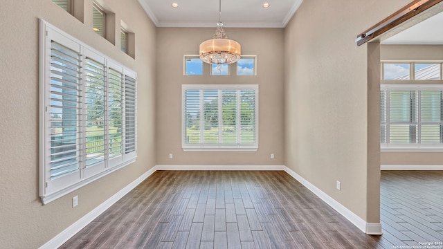 unfurnished room with crown molding, dark hardwood / wood-style flooring, and an inviting chandelier