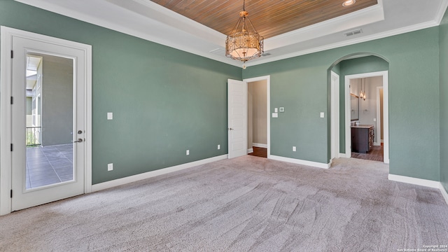 spare room with wooden ceiling, ornamental molding, carpet flooring, and a raised ceiling