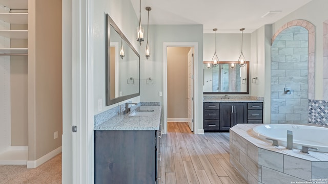 bathroom featuring dual vanity, shower with separate bathtub, and hardwood / wood-style floors