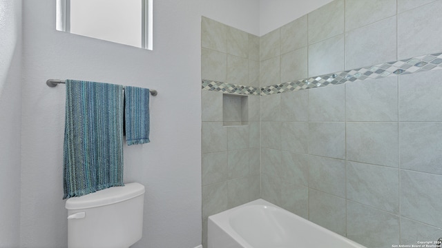 bathroom with tiled shower / bath and toilet