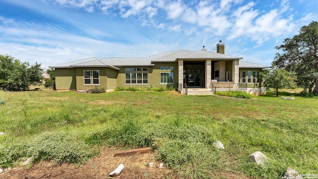 back of house featuring a lawn and covered porch